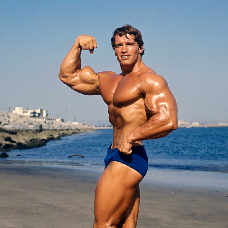 Arnold flexing on the beach